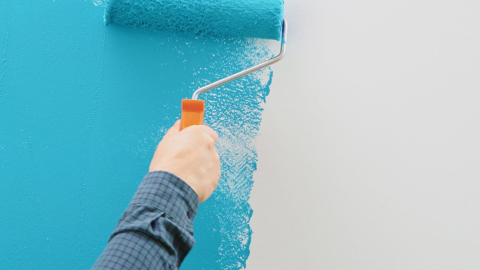 Professional painting with a roller on a blue wall in Inland Empire.