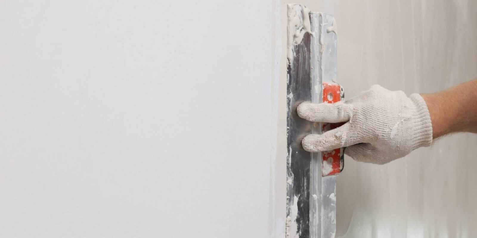 Worker smoothing wall surface during painting process in Inland Empire.