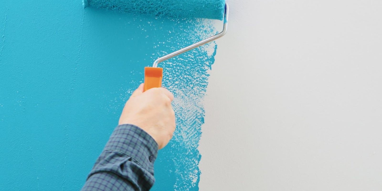 Professional painting with a roller on a blue wall in Inland Empire.